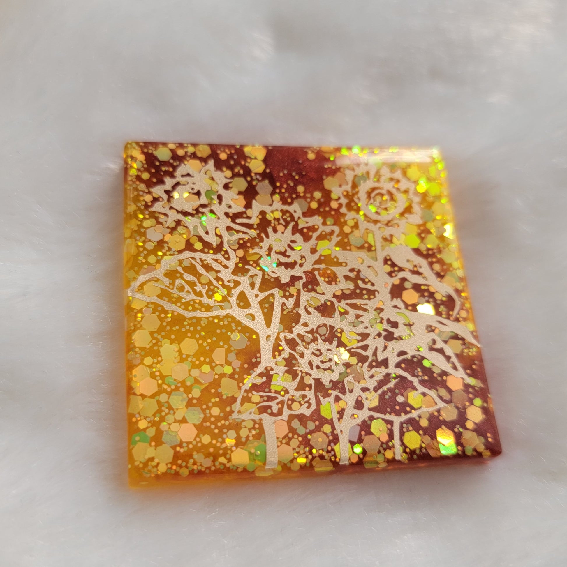 Square epoxy resin piece, yellow glitter and rust mica pigment swirls with gold vinyl sunflower design.