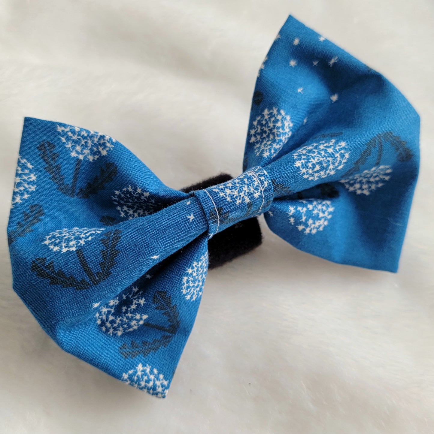 Fabric pet bowtie, deep blue cotton with white and black dandelions print.