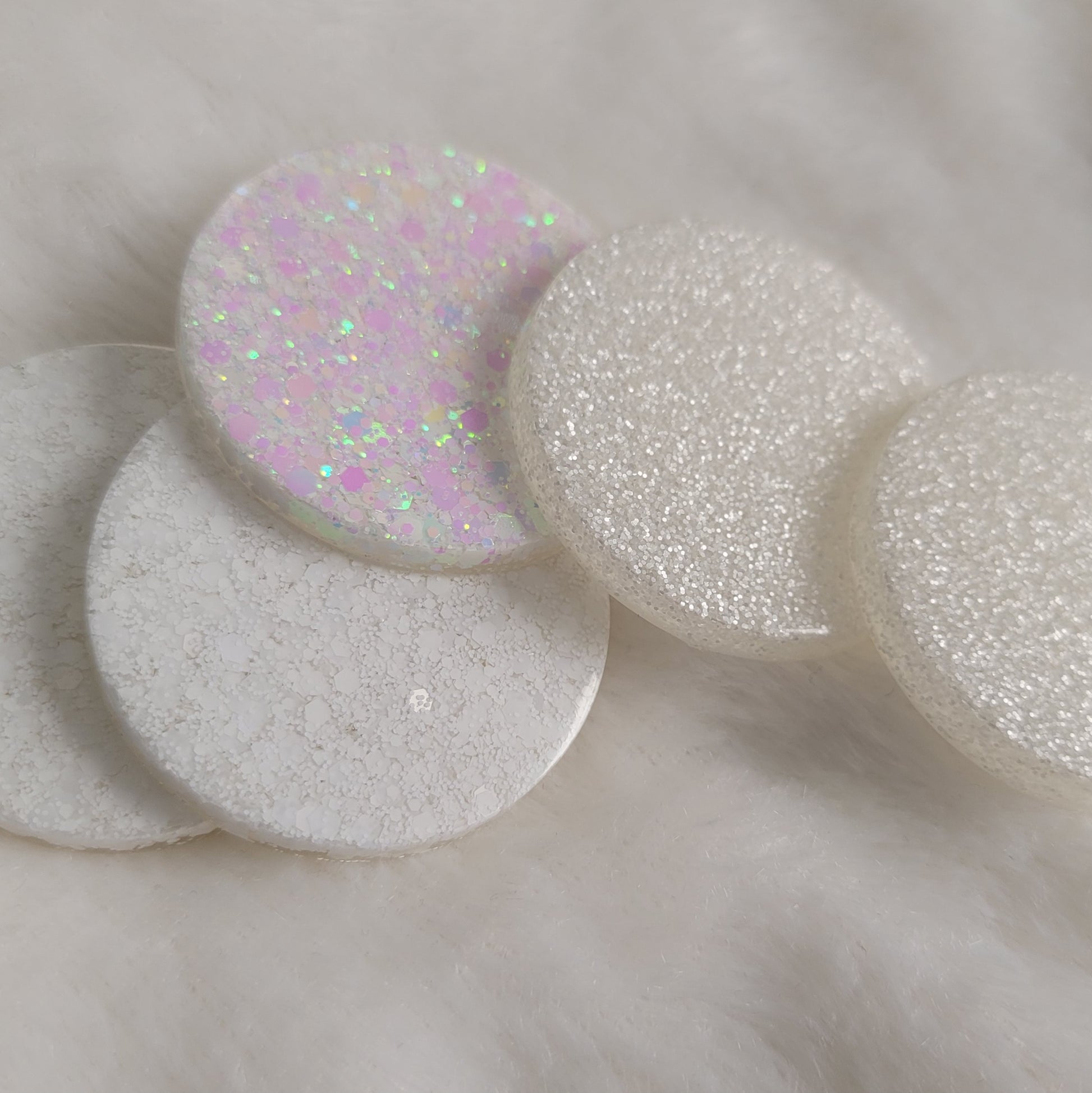 Five round epoxy resin pieces with matte, satin, and iridescent white glitter.