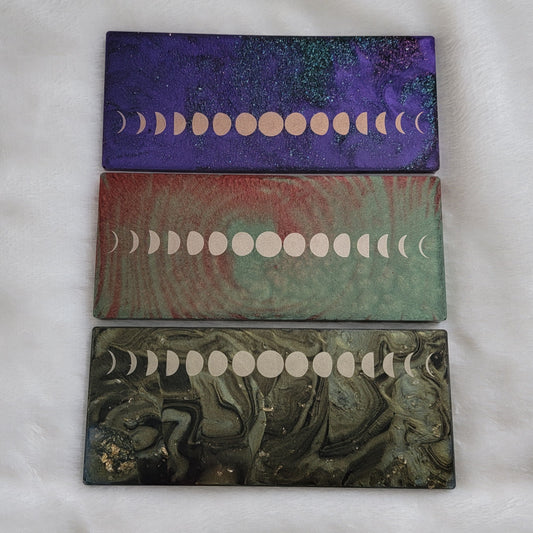 Three rectangular epoxy resin pieces with metallic moon phases motif.