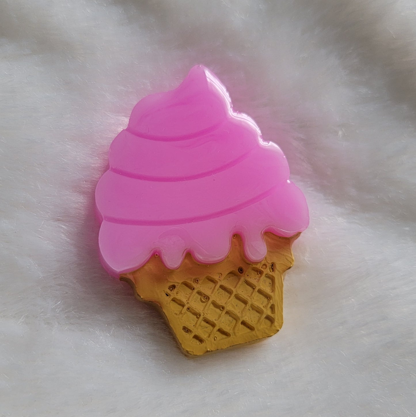 Ice cream cone shaped epoxy resin piece, bright pink color mimics cotton candy flavored ice cream and cone details painted in acrylic paint.