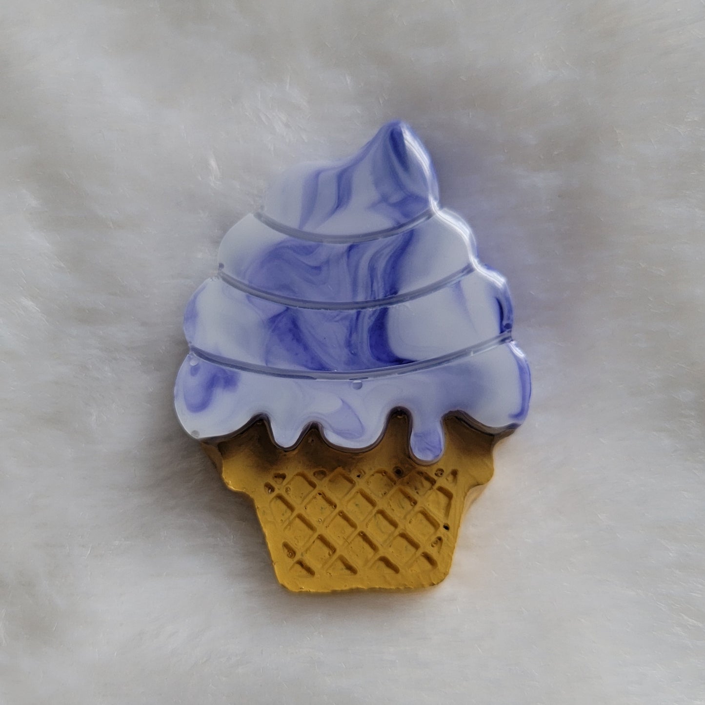 Ice cream cone shaped epoxy resin piece, blue and white swirls mimic blueberry swirl ice cream and cone details painted in acrylic paint.