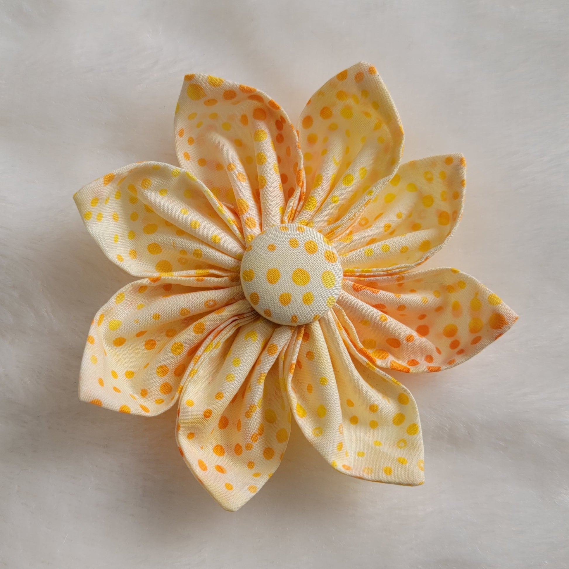 Bright orange and yellow dot batik pattern on white fabric flower.