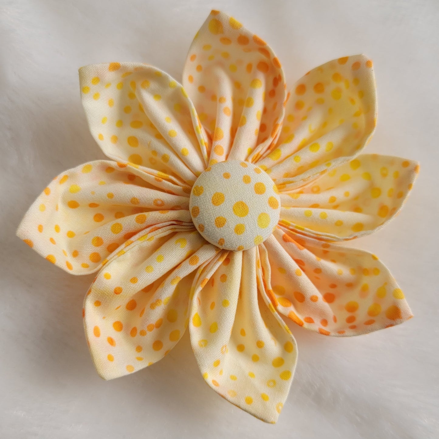 Bright orange and yellow dot batik pattern on white fabric flower.