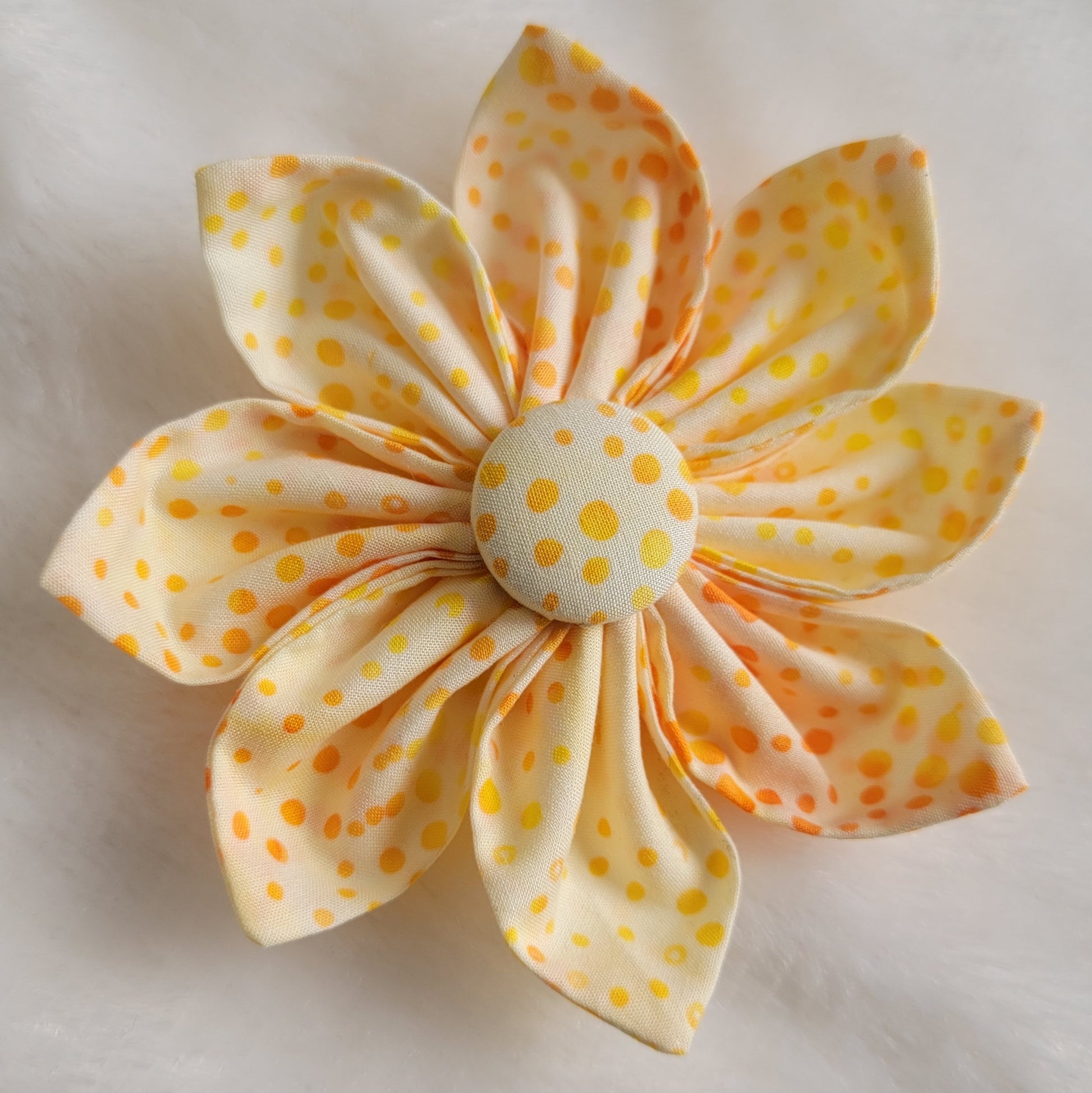 Bright orange and yellow dot batik pattern on white fabric flower.