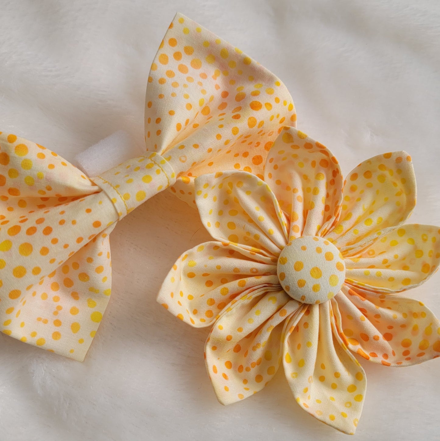 Bright orange and yellow dot batik pattern on white fabric flower and bowtie.