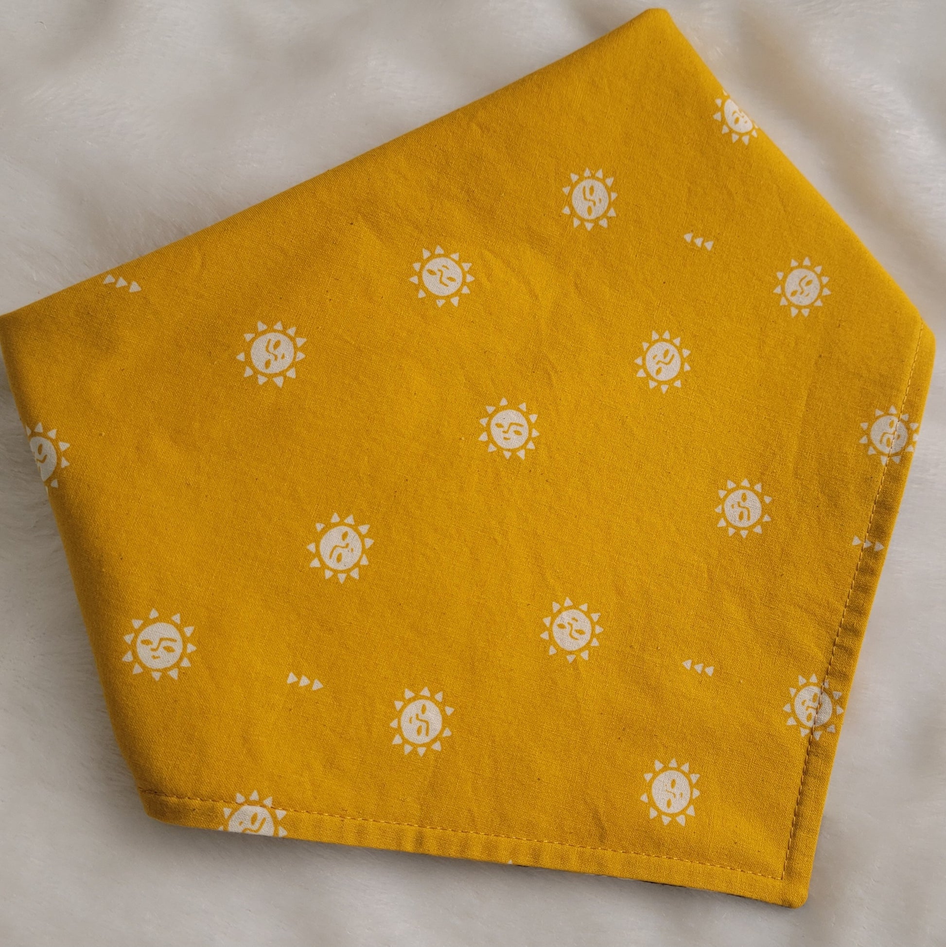 Reversible pet bandana with stylized suns print on bright mustard yellow.