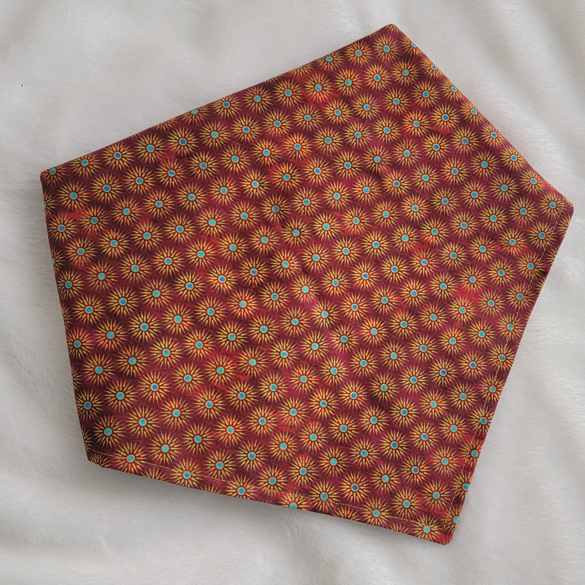 Reversible pet bandana, red and gold sunburst print.