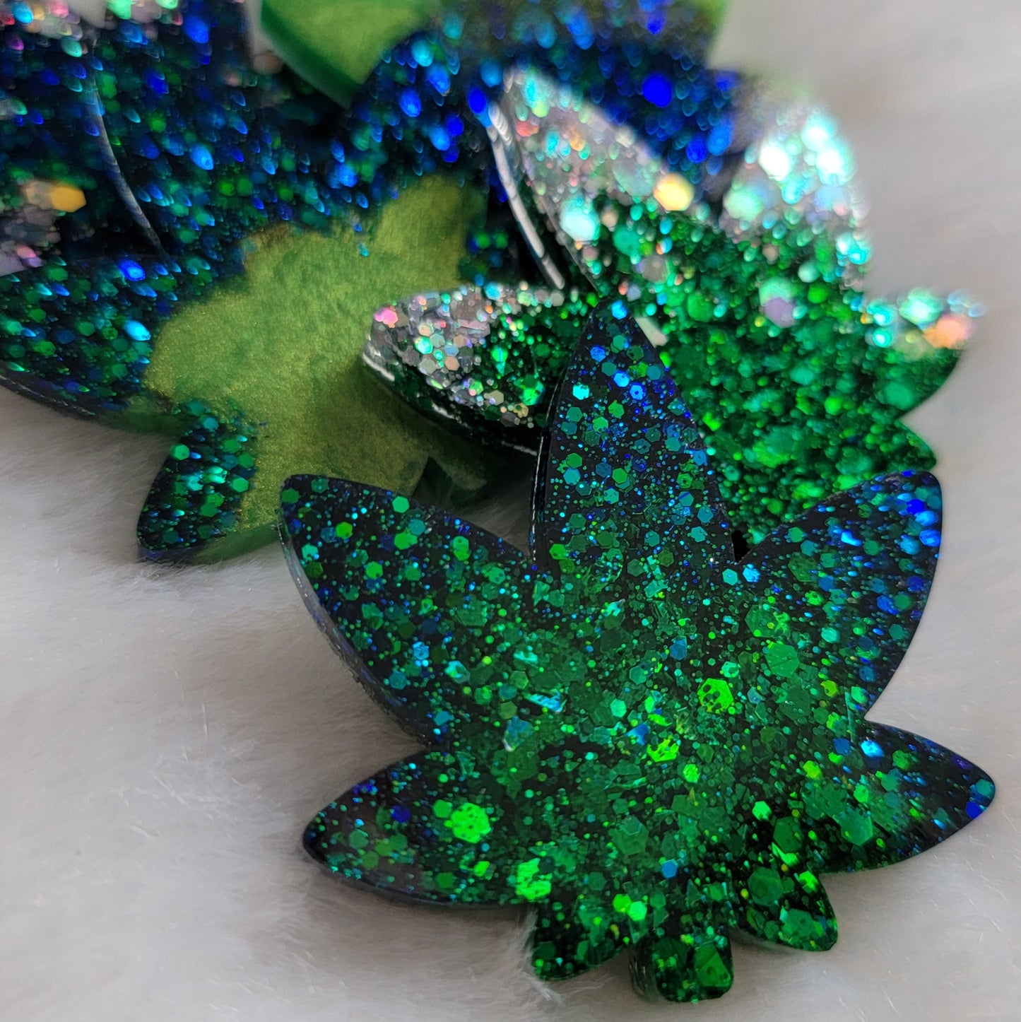 Green glitter cannabis leaf shaped epoxy resin pieces.