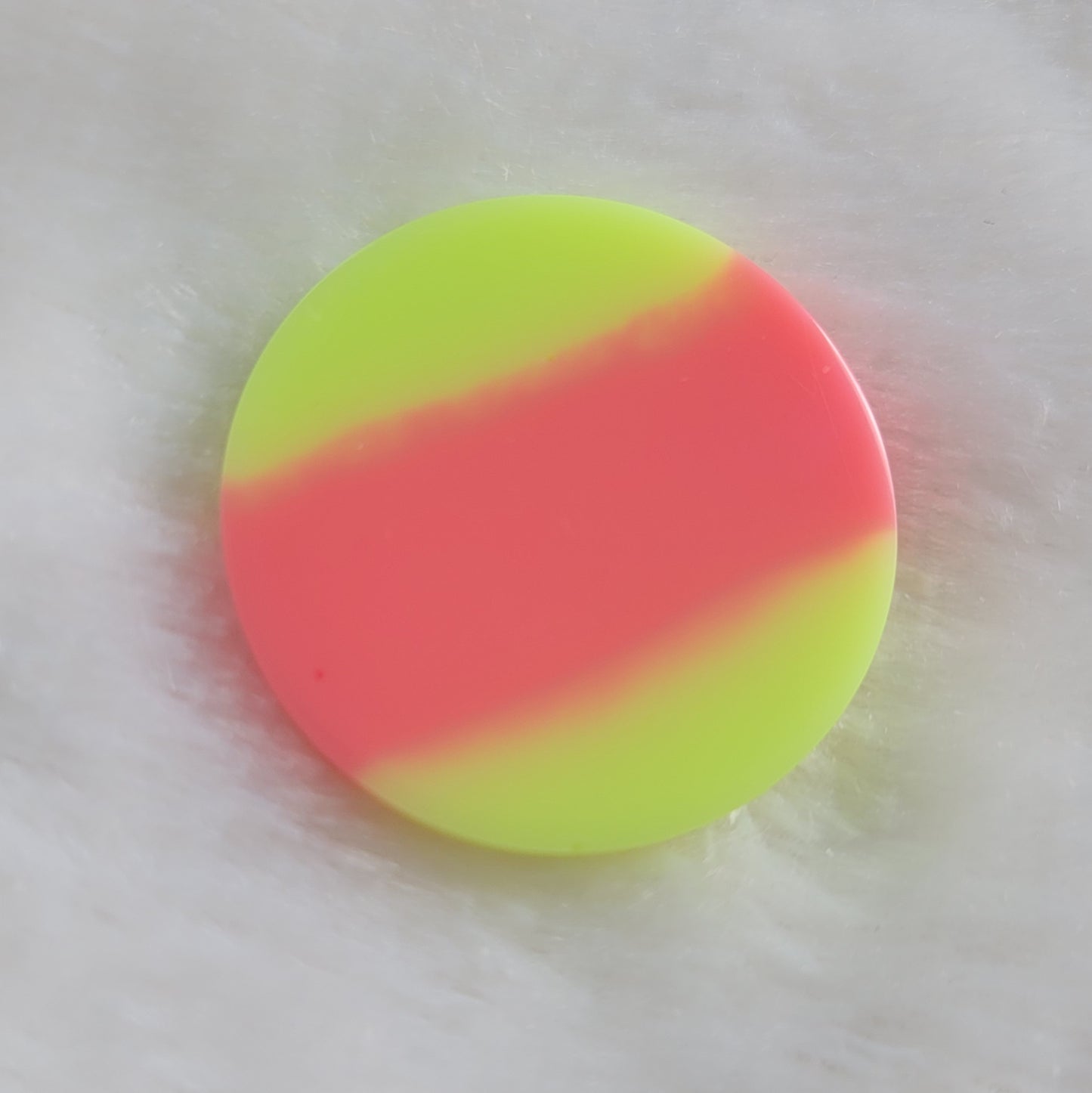 Round resin piece with neon pink stripe between neon yellow-green.