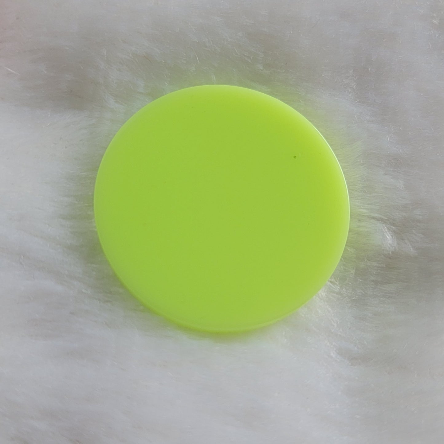 Round epoxy resin piece in bright neon yellow-green.