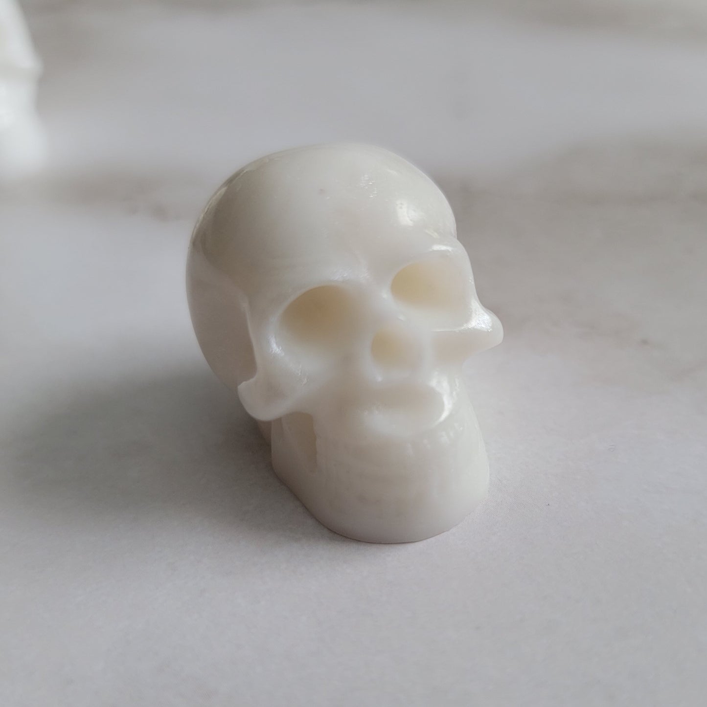 Small epoxy resin skull, bright white with pearl white swirls.