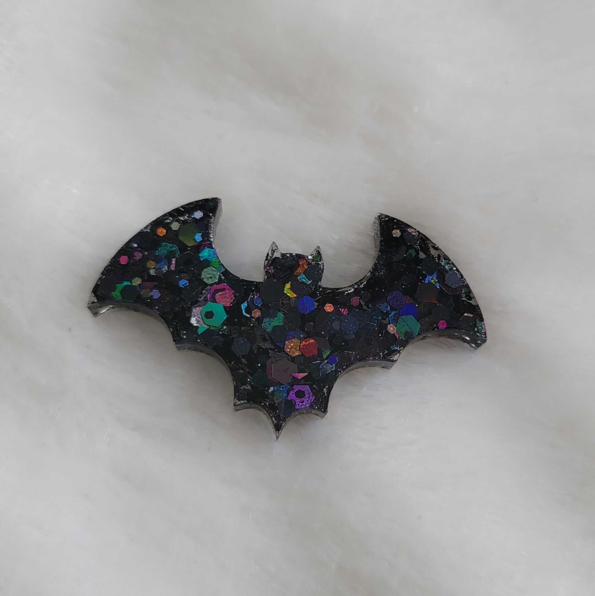 Chunky black holographic glitter bat shaped epoxy resin piece.