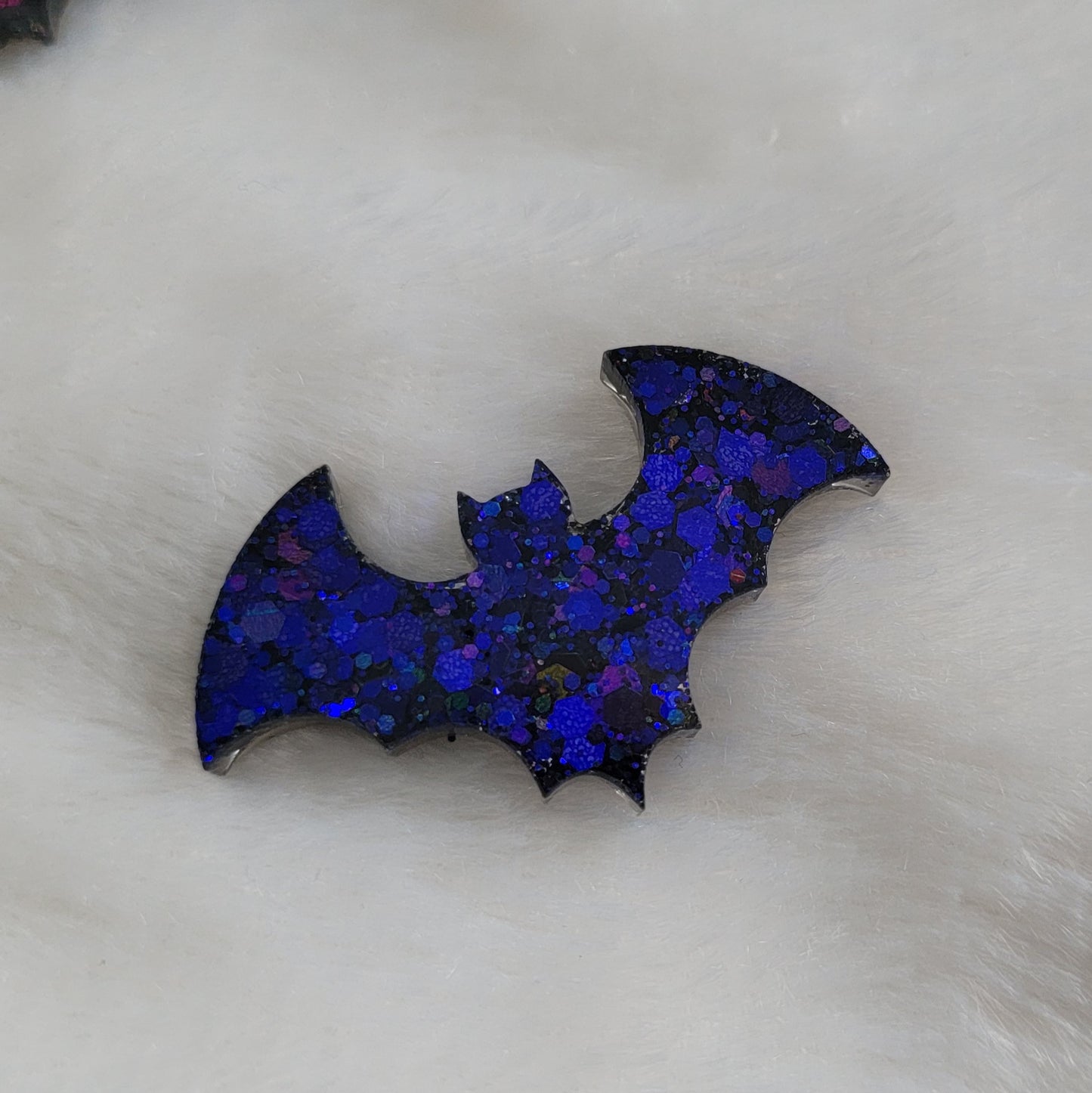 Dark holographic purple glitter bat shaped epoxy resin piece.