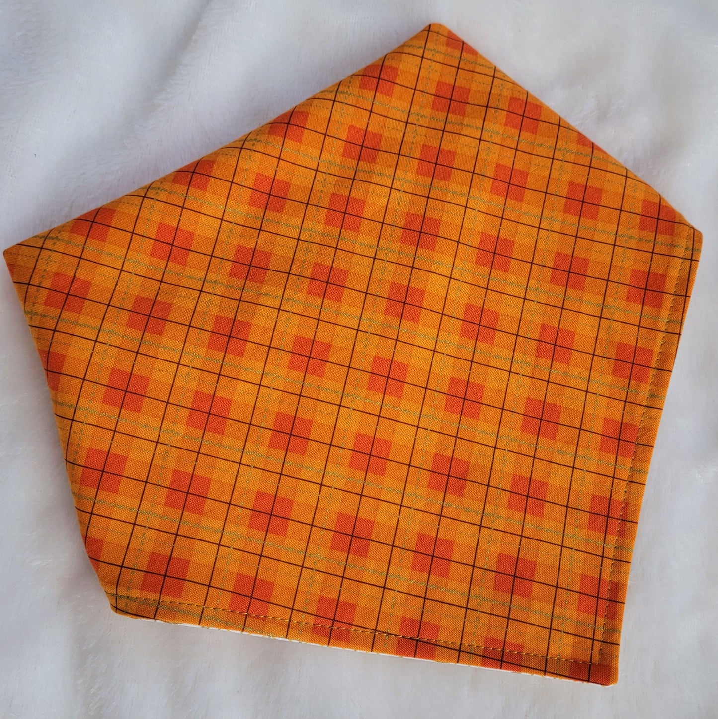 Reversible pet bandana, bright orange plaid side shown.