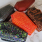 Five coffin shaped epoxy resin trinket boxes in Halloween themed colors.