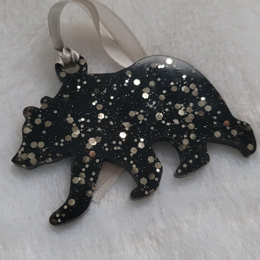 Bear shaped epoxy resin ornament, made with black pigment and warm silver glitter combined and a silver ribbon attached.