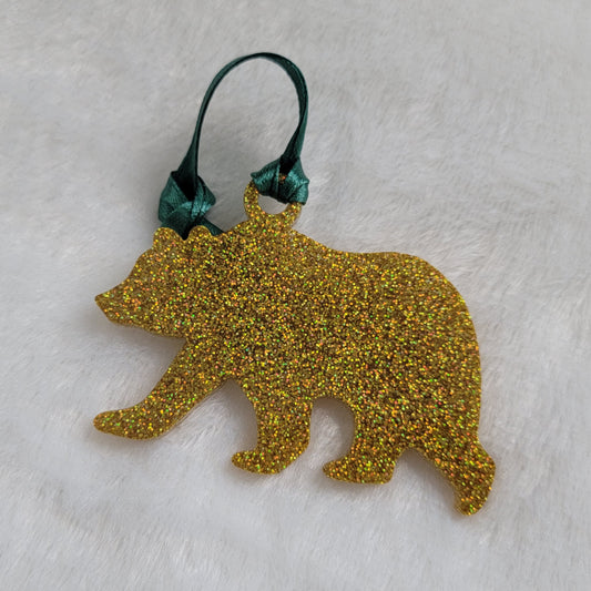 Bear shaped epoxy resin ornament, made with gold holographic glitter and a dark green ribbon attached.