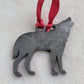 Wolf shaped epoxy resin ornament, made with dark silver pigment and a red ribbon attached.