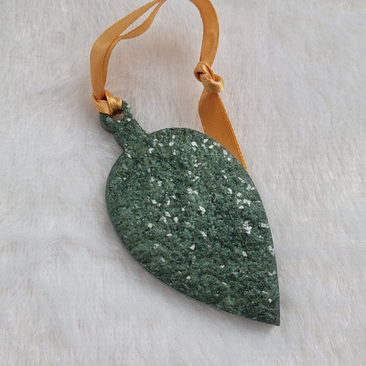 Drop shaped epoxy resin ornament that has a crystalline texture, made with green pigment and a gold ribbon attached.