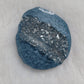 Irregular round epoxy resin piece made with ice blue mica pigment and silver crystalline texture inset running through the center of the piece.