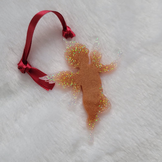 Cherub shaped epoxy resin ornament, made with golden bronze pigment and white iridescent glitter and a red ribbon attached.