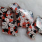 Six diamond shaped epoxy resin pieces, two each in three different sizes, filled with tiny polymer clay pieces shaped like card suits and aces.