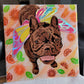 Portrait of a brown brindle French bulldog wearing rainbow fairy wings made with layers of adhesive vinyl on a canvas. The background has orange swirled acrylic paint and is adorned with shiny vinyl orange slices and leaves.