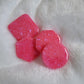 Four bright pink epoxy resin pieces with crystalline texture, one each - square, hexagon, octagon and round.
