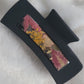 A black 4-inch claw clip with orange pressed flower and fall leaves cast in resin within an open space in the hair clip.