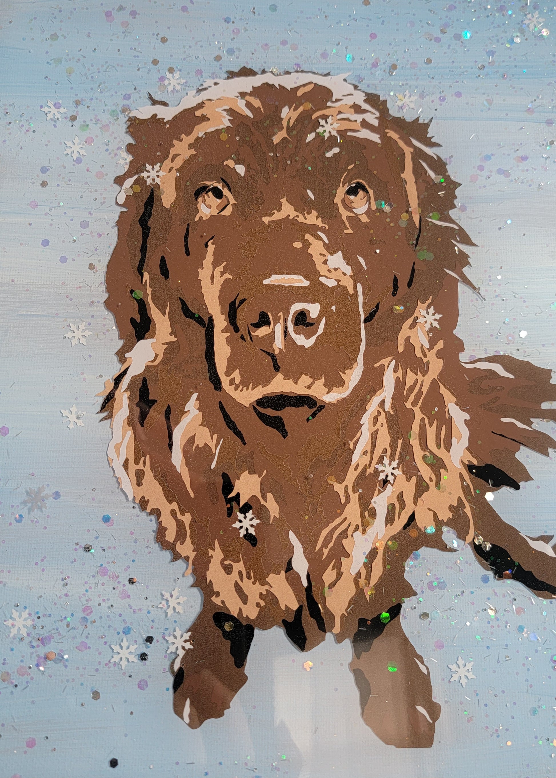 Vinyl art of a brown newfoundland dog on a canvas painted with light blue acrylic paint, adorned with snow glitter and sealed in epoxy resin.