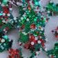 Array of star shaped epoxy resin pieces filled with red, green, and Christmas themed glitter, displayed on a white background.