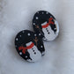Two dark blue sparkly oval-shaped epoxy resin pieces with snowman designs, displayed on a white background