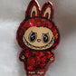 Labubu inspired epoxy resin pet tag, made with red glitter and acrylic painted details.
