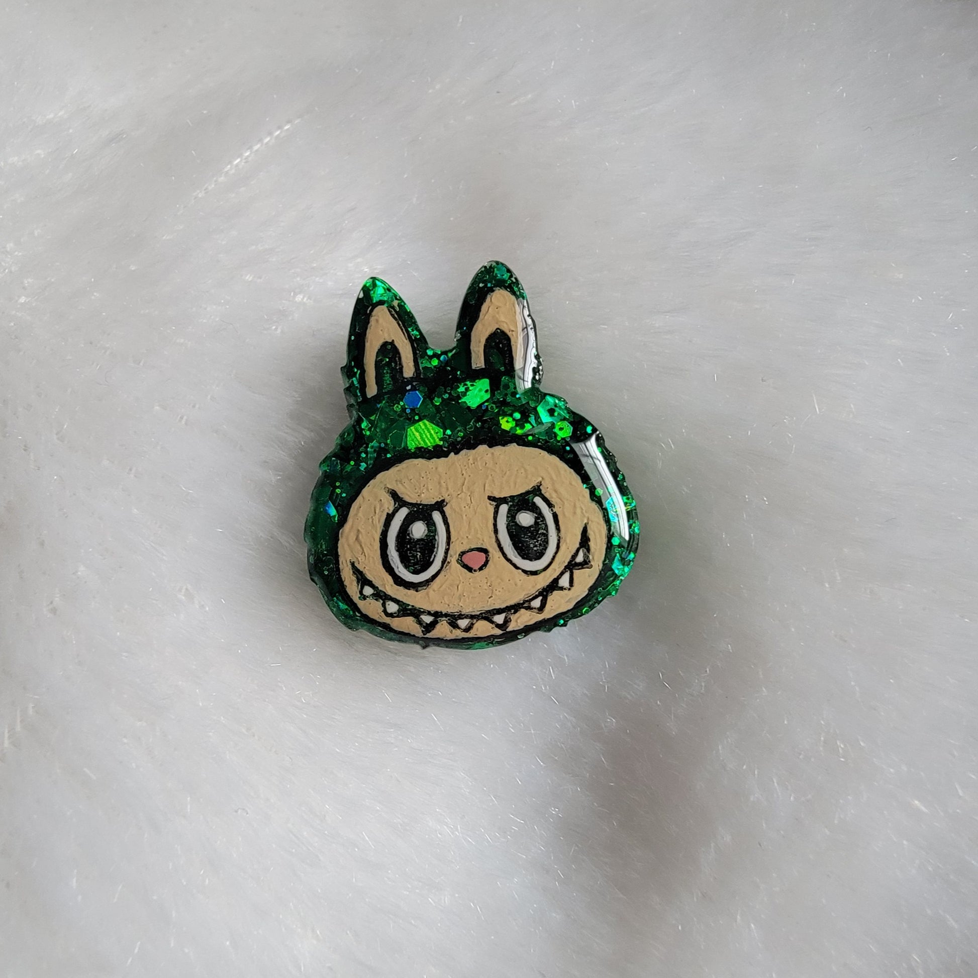 Labubu inspired small epoxy resin pet tag, made with green glitter and acrylic painted details.