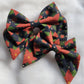 Two sailor bows made with poinsettia print cotton, displayed on a white background.