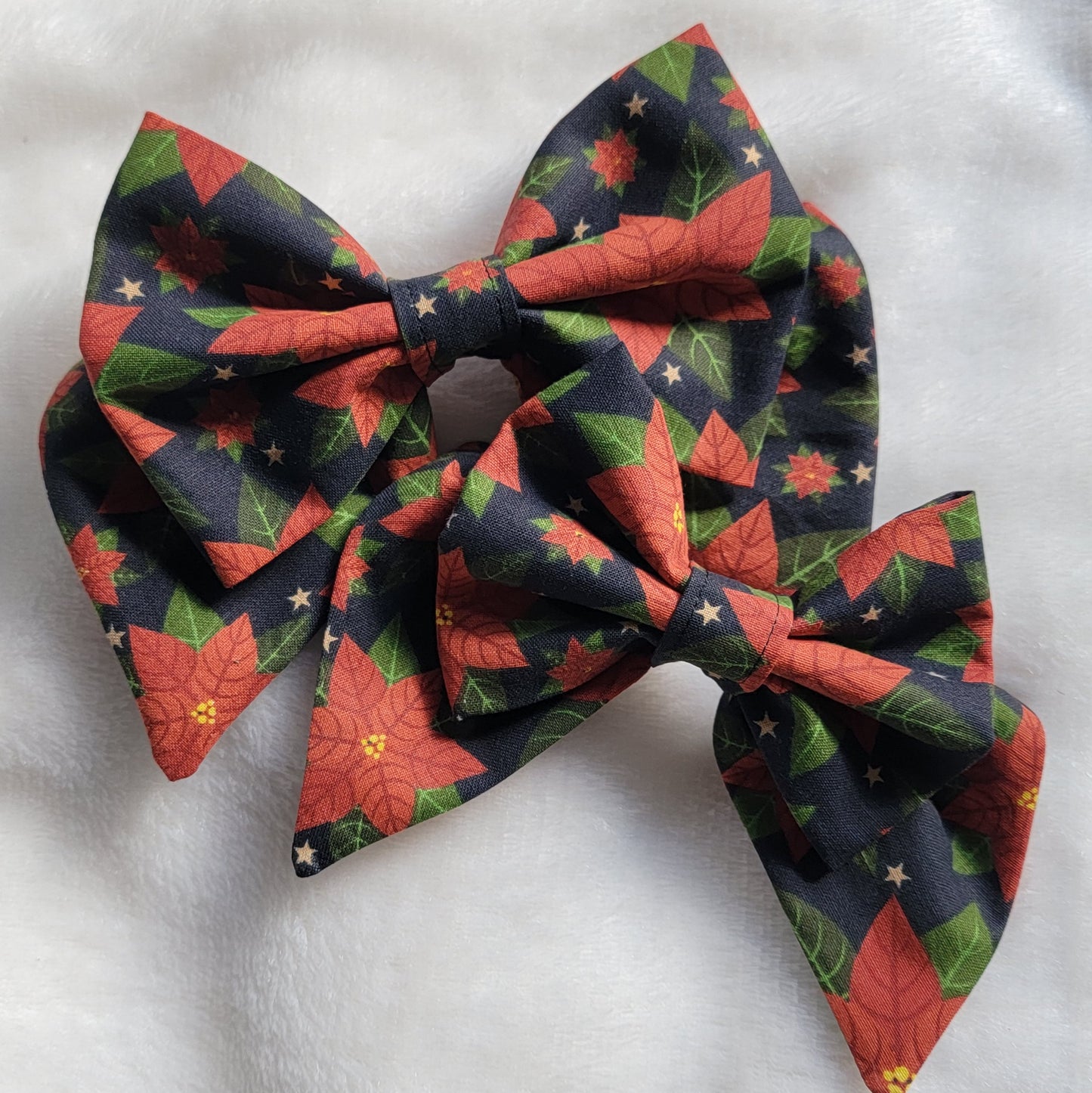 Two sailor bows made with poinsettia print cotton, displayed on a white background.