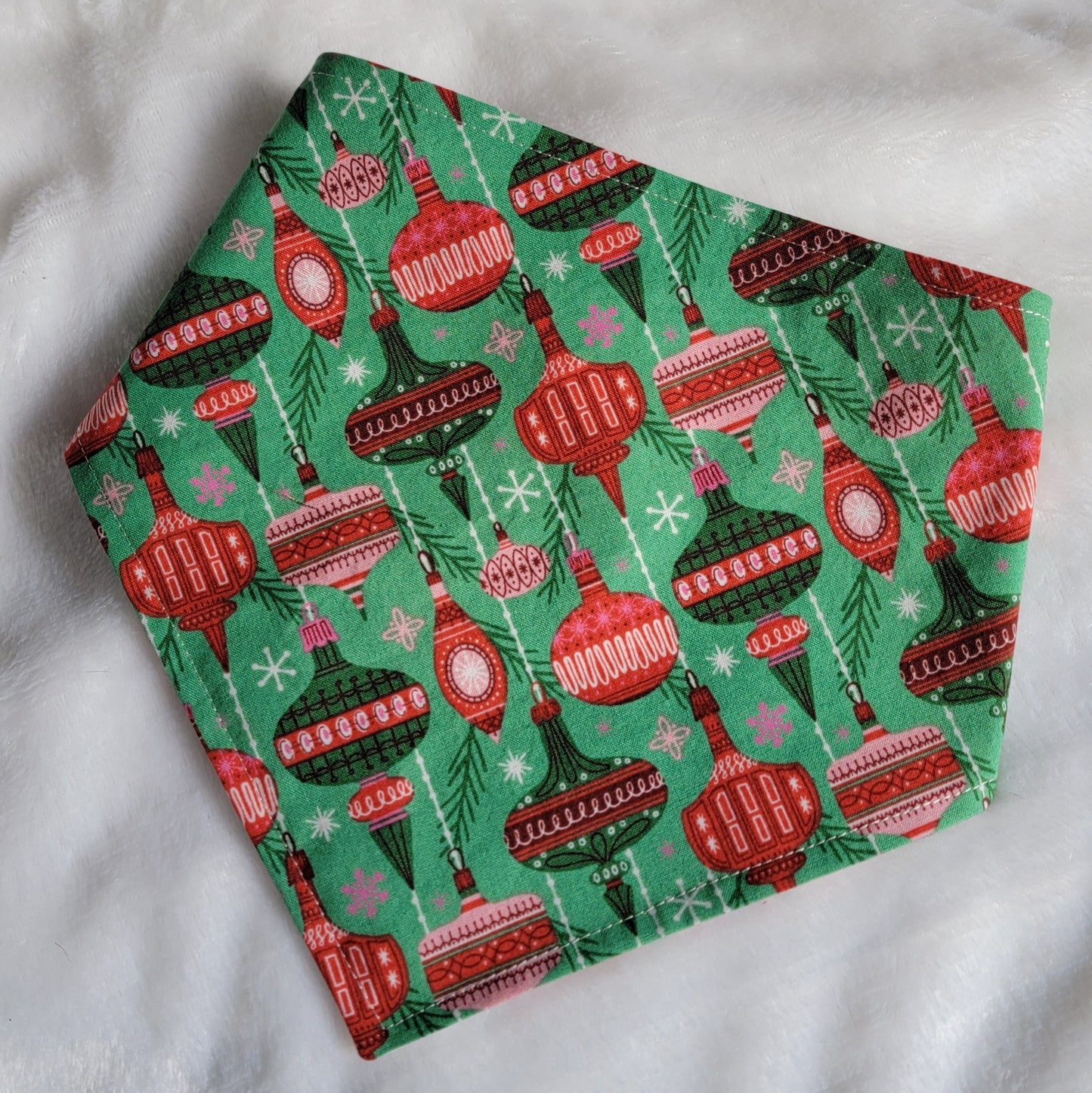 Handmade pet bandana with vintage ornaments design on green background.