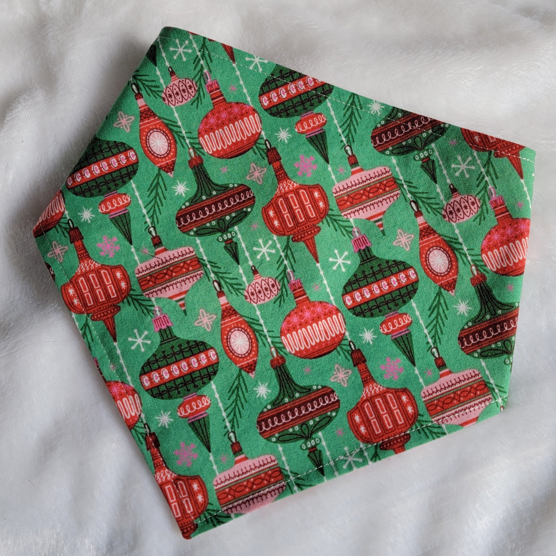 Handmade pet bandana with vintage ornaments design on green background.
