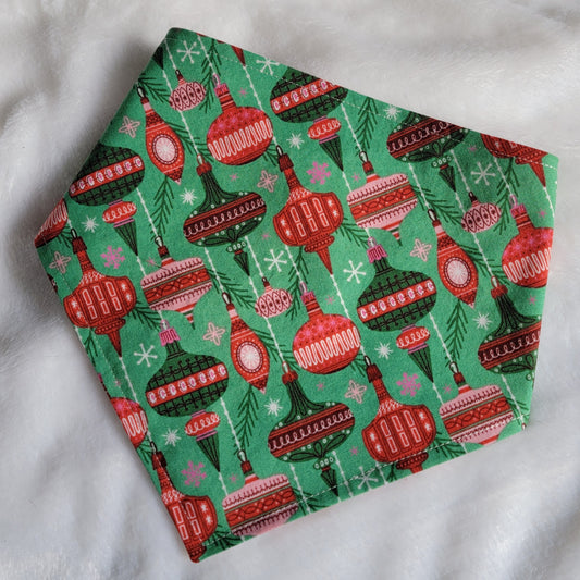 Handmade pet bandana with vintage ornaments design on green background.