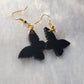 Small drop earrings made from black butterfly shaped epoxy resin pieces.