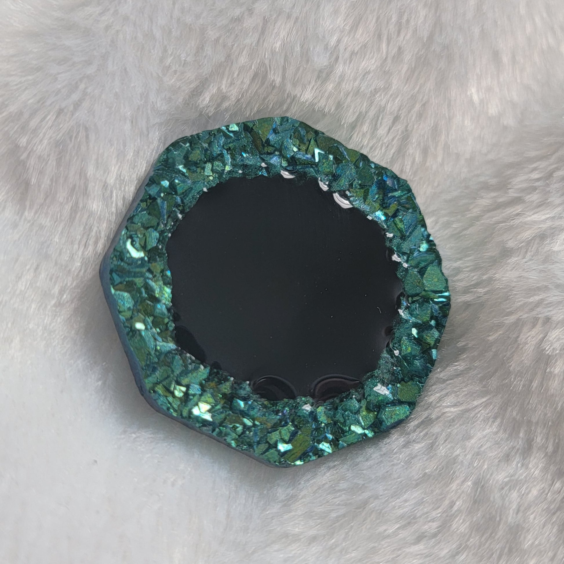Octagon shaped epoxy resin piece with green crystal texture border and black center, displayed on a white background.
