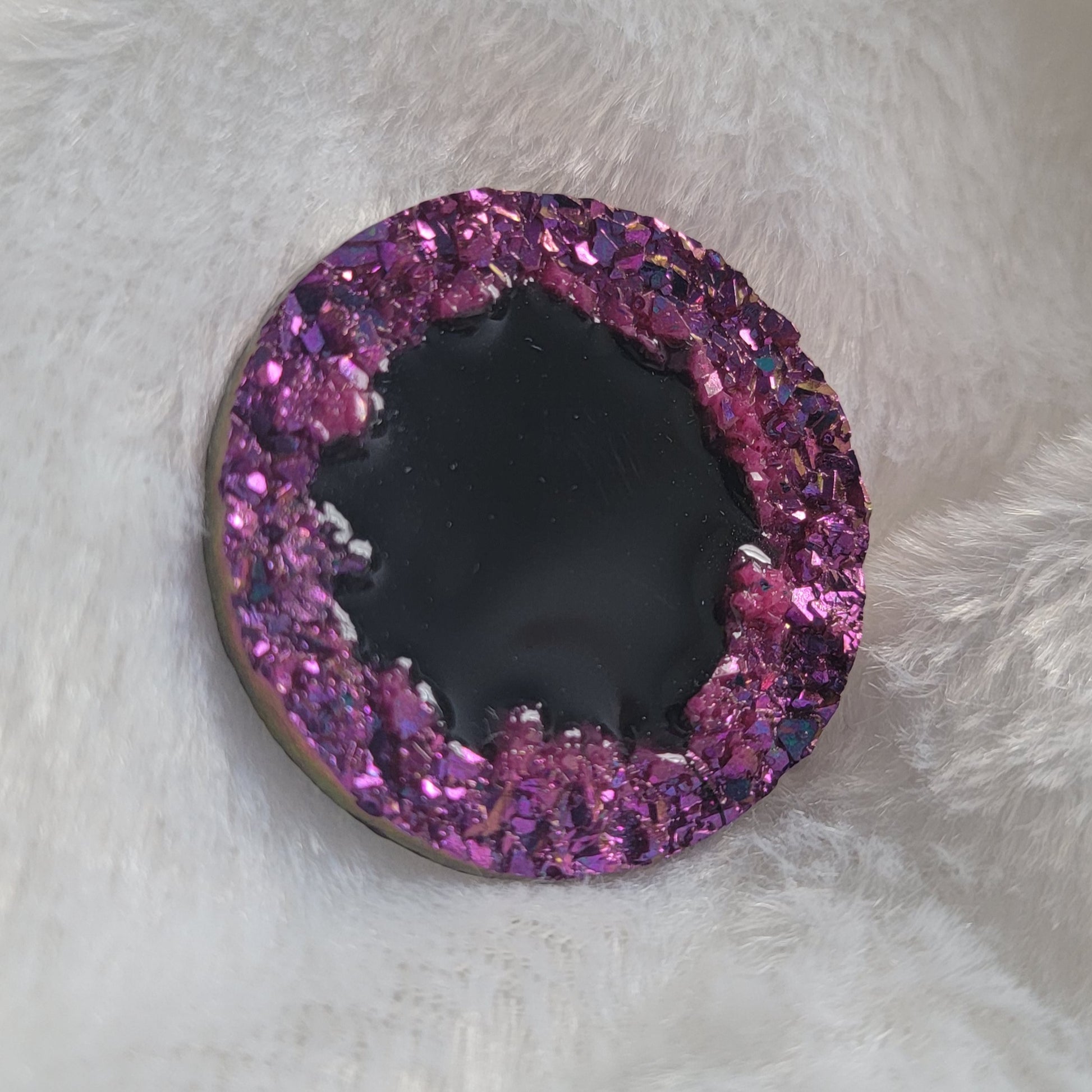 Round epoxy resin piece with purple crystal texture border and black center, displayed on a white background.