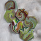Hexagon shaped epoxy resin pieces with swirling greens and rust colored pigments, displayed on a white background.