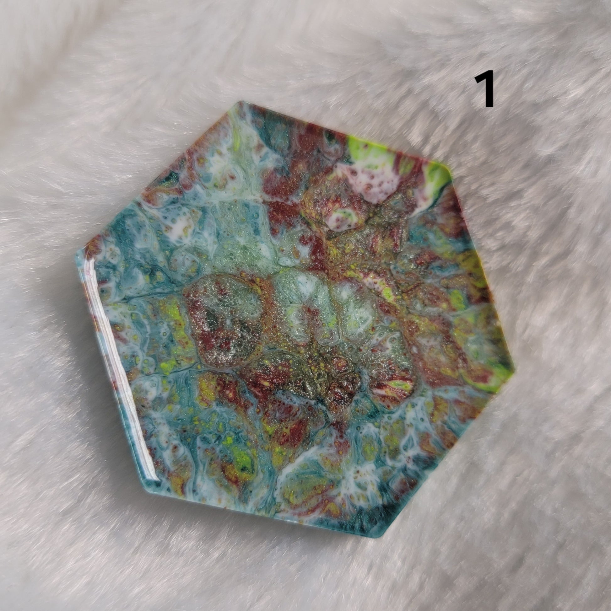Hexagon shaped epoxy resin piece with swirling greens and rust colored pigments, displayed on a white background. The number "1" is in the top right corner.