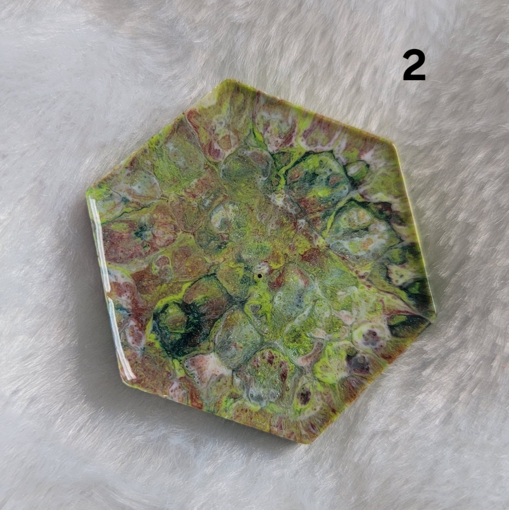 Hexagon shaped epoxy resin piece with swirling greens and rust colored pigments, displayed on a white background. The number "2" is in the top right corner.
