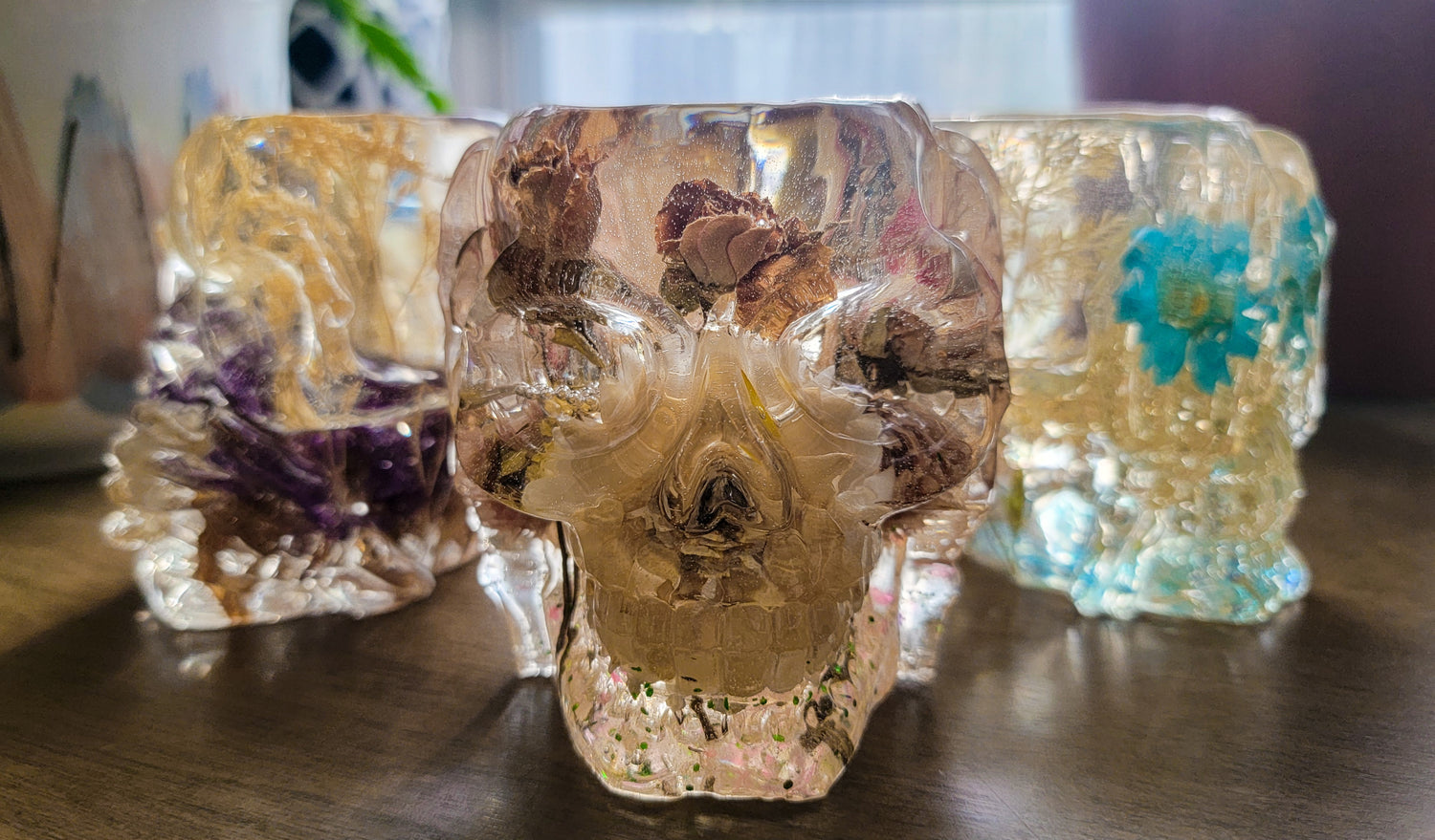 Three epoxy resin skulls filled with flowers.