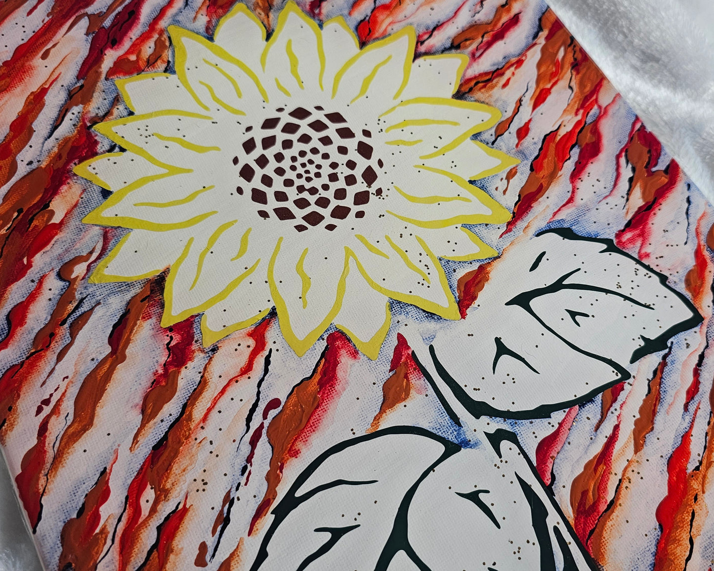 Close up of sunflower art made with yellow, green and brown vinyl, with rust and navy blue acrylic abstract painted background on white; accented with gold glitter and sealed in epoxy resin.