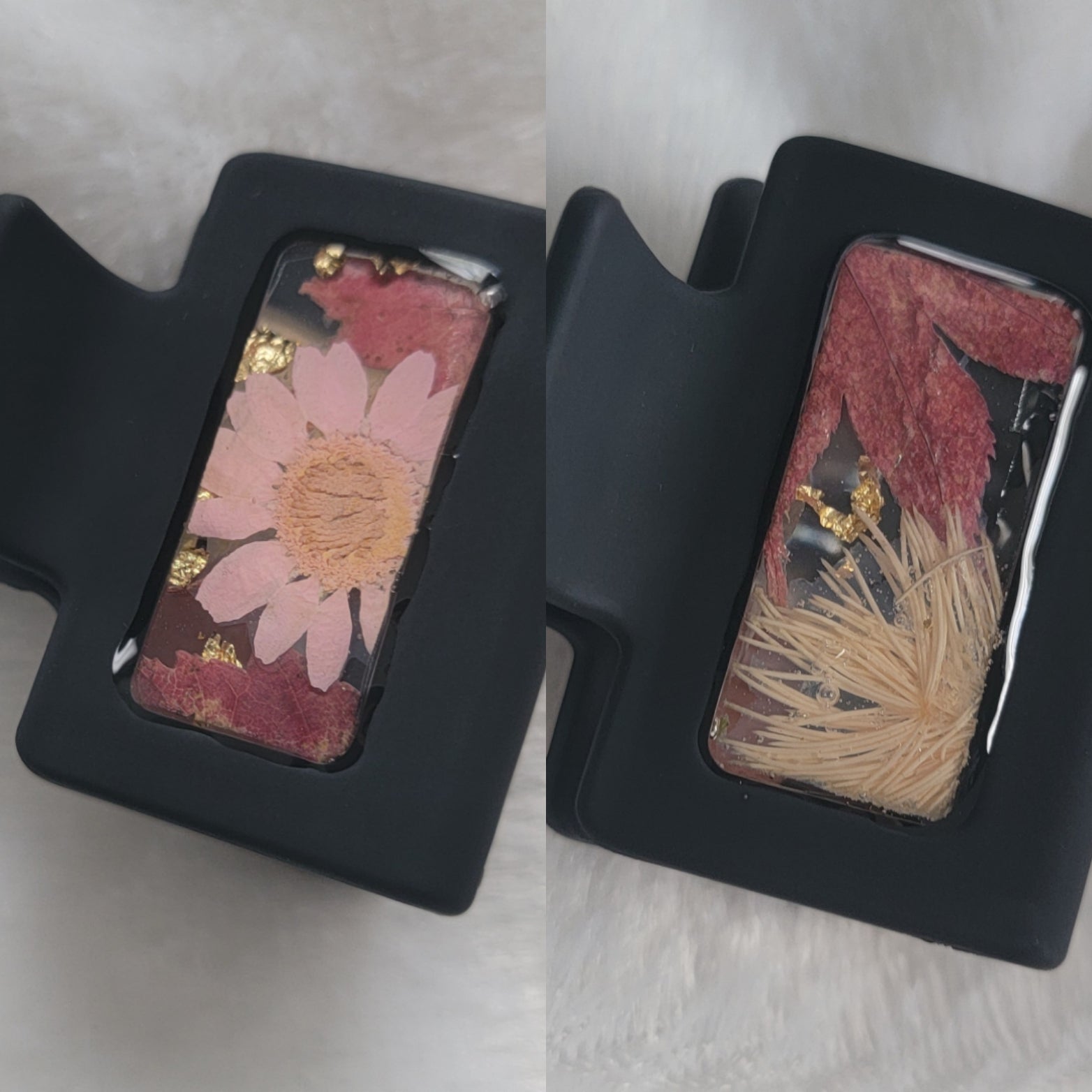 A black 2-inch claw clip with white and pink pressed flowers and fall leaves cast in resin within an open space in the hair clip.