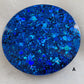 Close up of round epoxy resin piece made with deep blue glitter.
